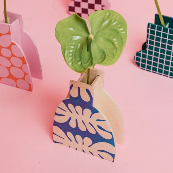 Drewniany wazon dekoracyjny. Z tłem w kolorze drewna i niebieskimi wzorami. 